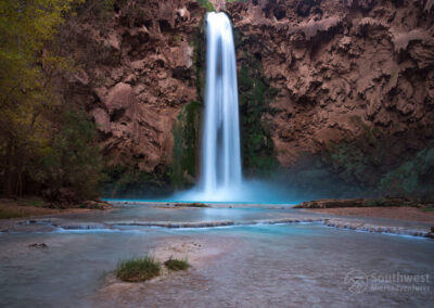 A view of Mooney Falls with a little island in the middle of the creek.